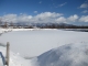 雪が積もって白くなったため池